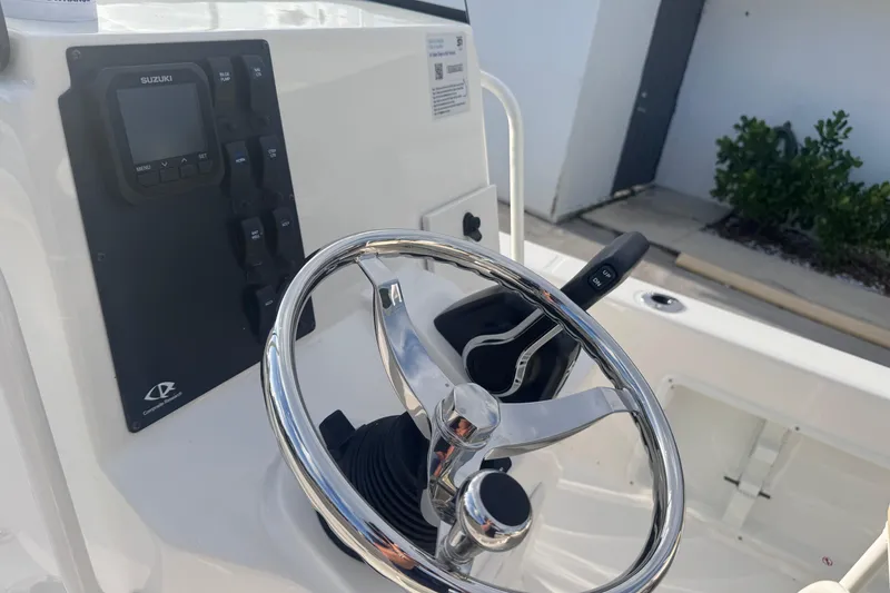 Slide: The Image of Steering console of 2026 Sundance DX22 boat with Suzuki controls and chrome wheel. - 14