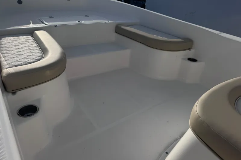 Slide: The Image of Interior seating of 2026 Sundance DX22 boat with beige cushions and cup holders. - 7