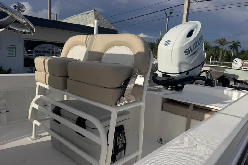 Slide: The Image of 2026 Sundance DX22 boat interior with beige seating and Suzuki outboard motor. - 9