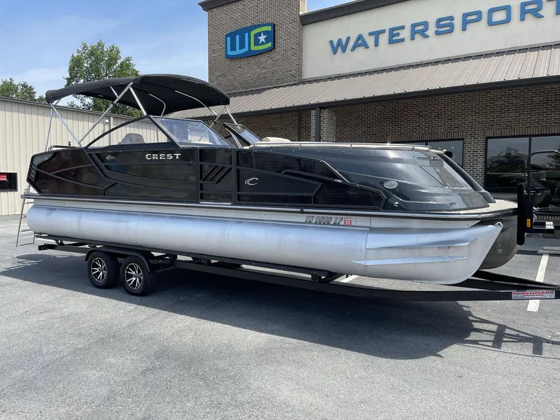 The Image of 2021 Crest 270 Continental pontoon boat outside watersports store. - 1