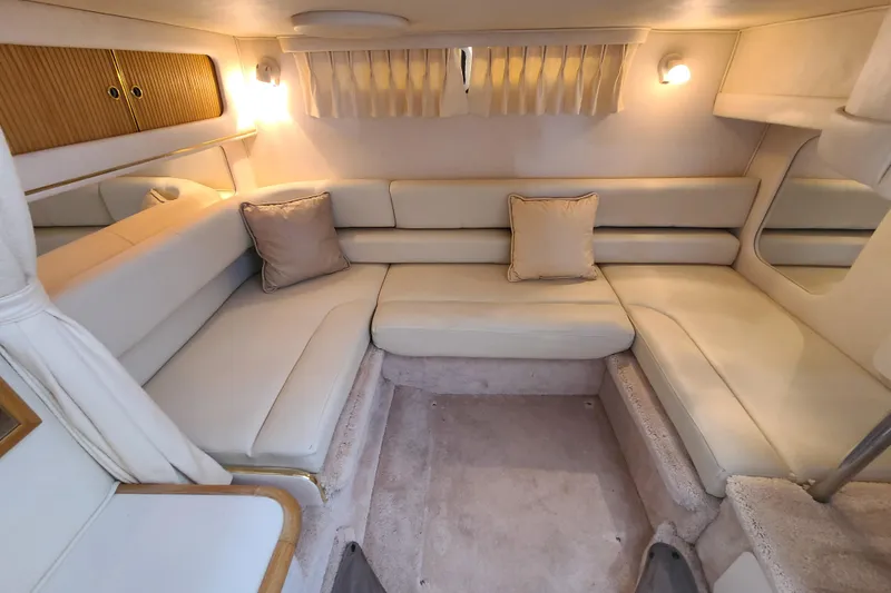 Slide: The Image of Interior of 1999 Sea Ray Sundancer 310, featuring cozy seating and ambient lighting. - 12