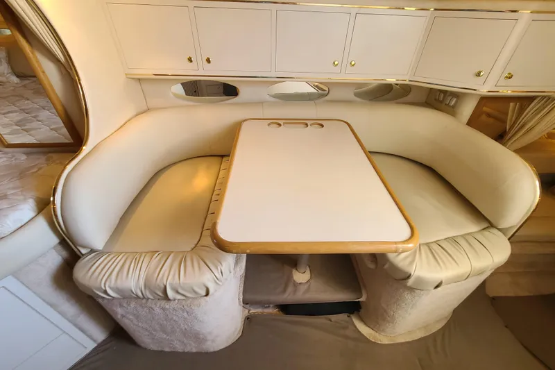 Slide: The Image of Interior of 1999 Sea Ray Sundancer 310 with cozy dining area and white cabinetry. - 13