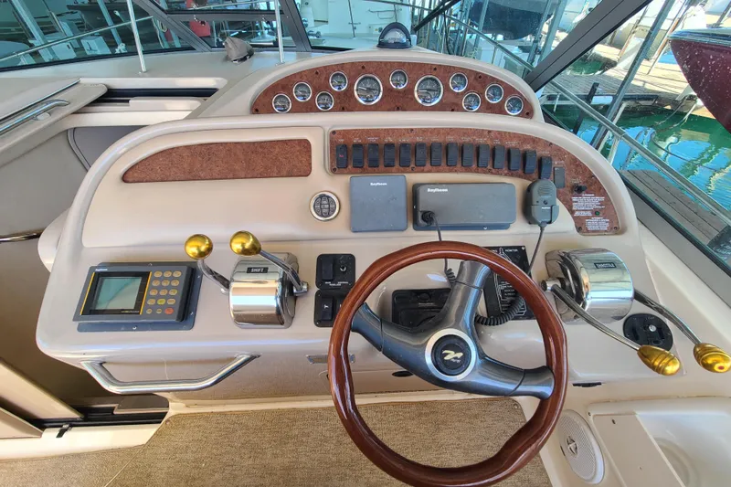 Slide: The Image of 1999 Sea Ray Sundancer 310 helm with steering wheel, controls, and navigation instruments. - 17