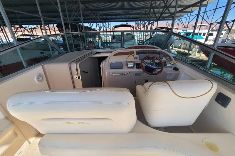 Slide: The Image of 1999 Sea Ray Sundancer 310 cockpit with steering wheel and seating in marina. - 18
