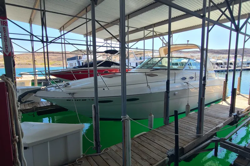 Slide: The Image of 1999 Sea Ray Sundancer 310 docked in a marina under a covered structure. - 2