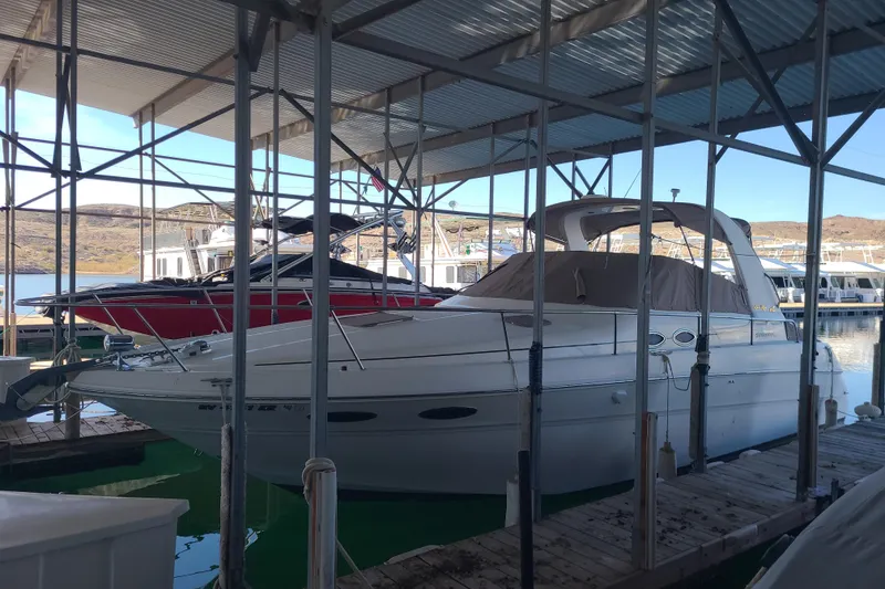 Slide: The Image of 1999 Sea Ray Sundancer 310 docked in a marina under a covered structure. - 3