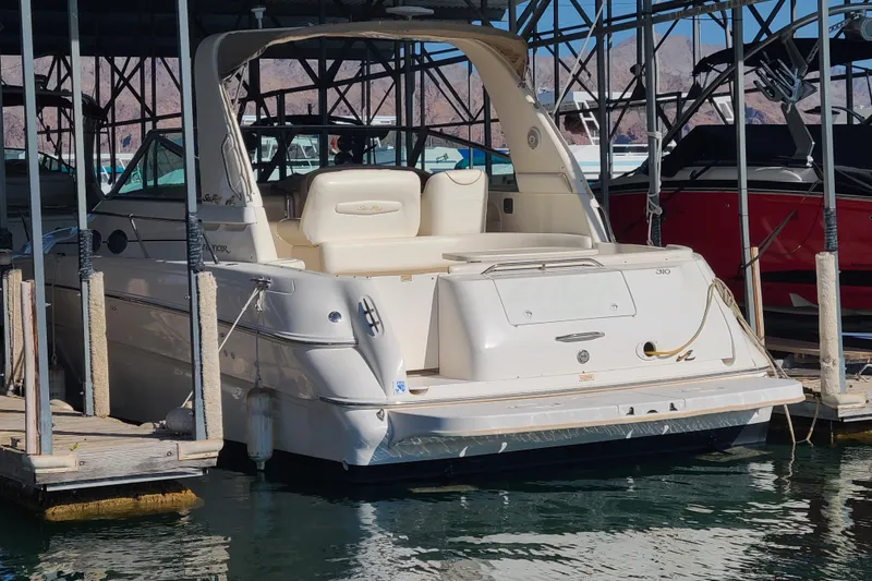 Slide: The Image of 1999 Sea Ray Sundancer 310 docked in a marina, showcasing its sleek design and spacious deck. - 4