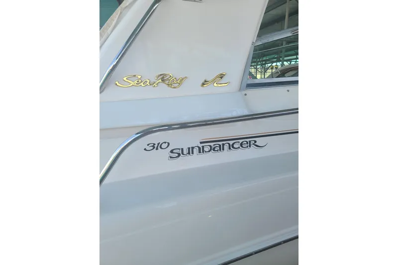 Slide: The Image of 1999 Sea Ray Sundancer 310 boat side view with logo and model name. - 6