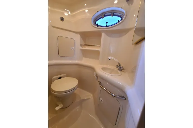 Slide: The Image of Bathroom interior of 1999 Sea Ray Sundancer 310 yacht, featuring toilet, sink, and porthole window. - 8