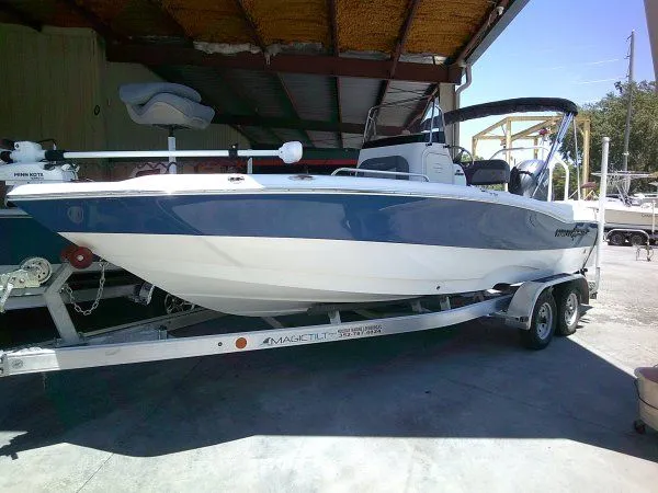 The Image of 2024 NauticStar 211 Hybrid boat on trailer in garage. - 1