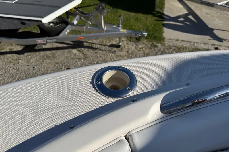 Slide: The Image of 2015 Robalo R227 Dual Console boat detail with rod holder and trailer in background. - 13