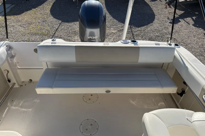 Slide: The Image of 2015 Robalo R227 Dual Console boat interior with Yamaha 200 engine, featuring a foldable bench seat. - 16