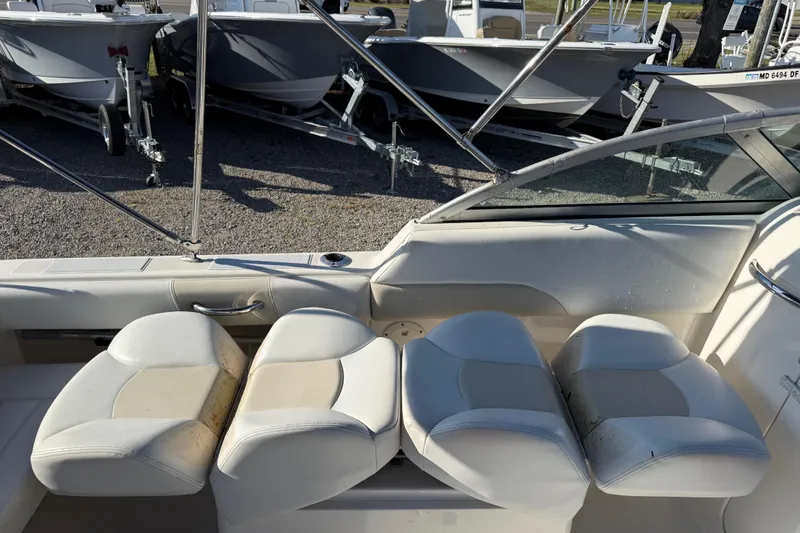 Slide: The Image of 2015 Robalo R227 Dual Console boat interior with white seating and cup holder. - 20