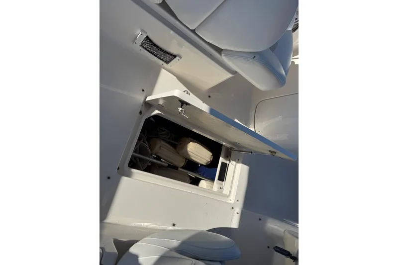 Slide: The Image of Storage compartment on a 2015 Robalo R227 Dual Console boat, open with visible contents. - 24