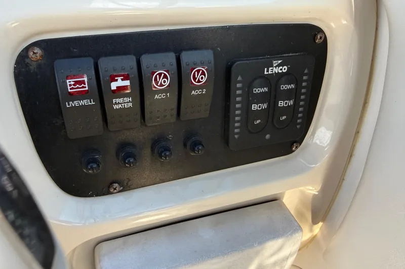 Slide: The Image of Control panel of a 2015 Robalo R227 Dual Console boat with switches and Lenco trim tabs. - 27