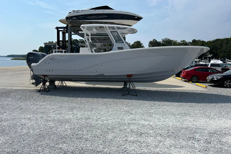 Slide: The Image of 2024 Sea Fox 328 Commander boat displayed on stands at a marina. - 1