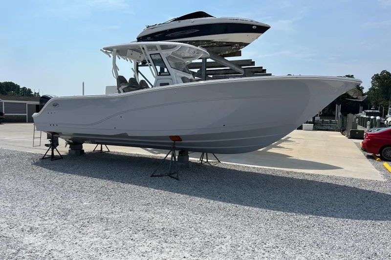 Slide: The Image of 2024 Sea Fox 328 Commander boat displayed on gravel lot under clear sky. - 2