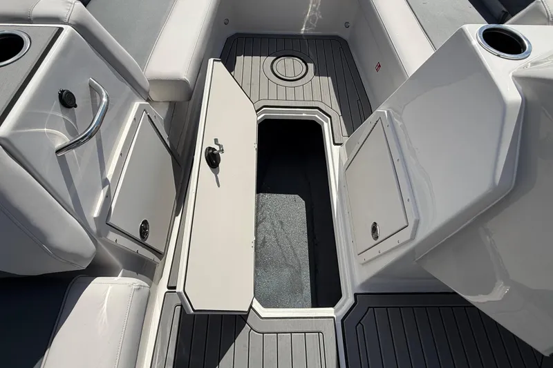 Slide: The Image of 2026 Starcraft SVX 211 OB boat interior with open storage compartment and sleek seating. - 18