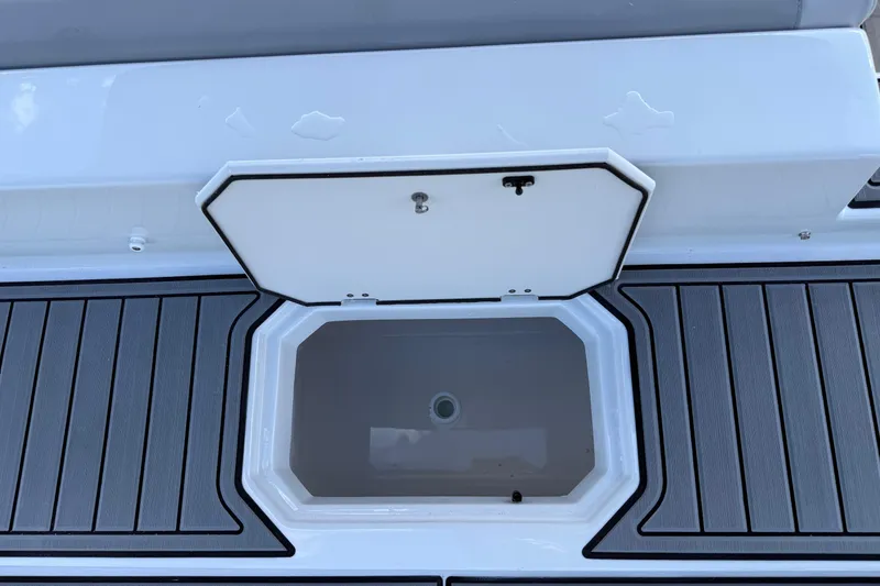 Slide: The Image of 2026 Starcraft SVX 211 OB boat storage compartment with open lid on deck. - 23