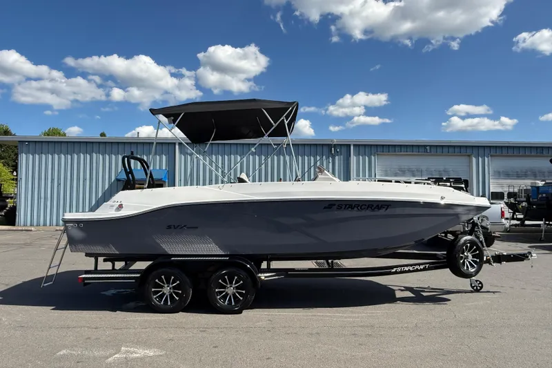Slide: The Image of 2026 Starcraft SVX 211 OB boat on trailer, parked outdoors under blue sky. - 3