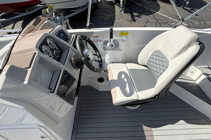 Slide: The Image of 2026 Starcraft SVX 211 OB boat cockpit with steering wheel and cushioned seat. - 9