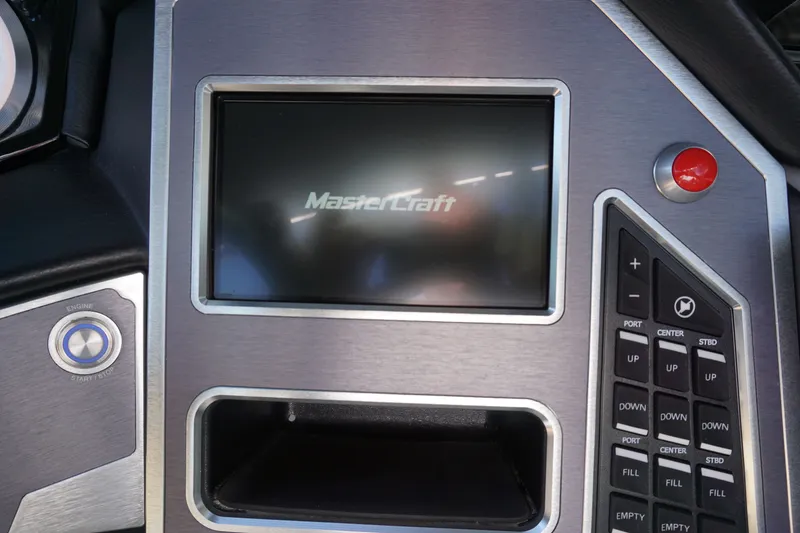 Slide: The Image of 2023 MasterCraft XT22 T boat control panel with display and buttons. - 17