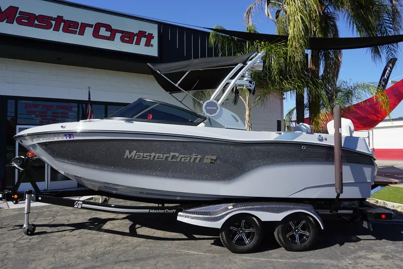 Slide: The Image of 2023 MasterCraft XT22 T boat outside showroom. - 2