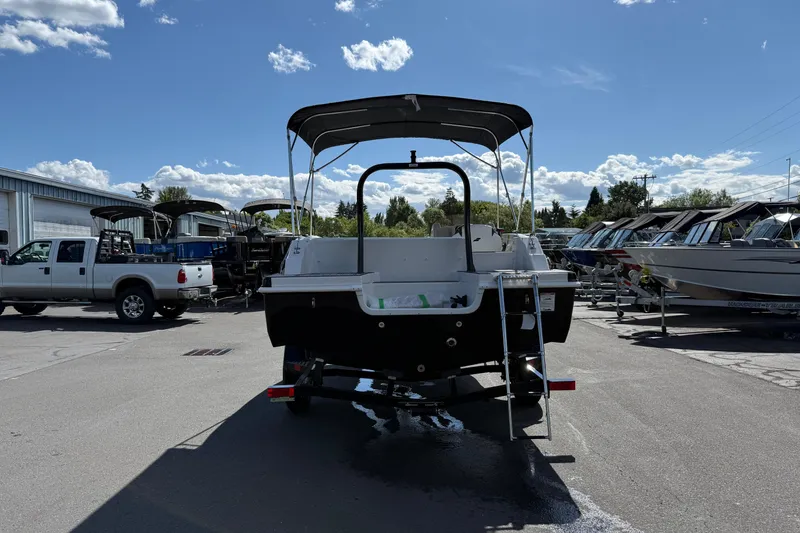 Slide: The Image of 2026 Starcraft SVX 191 OB boat with canopy, parked outdoors under a clear sky. - 3