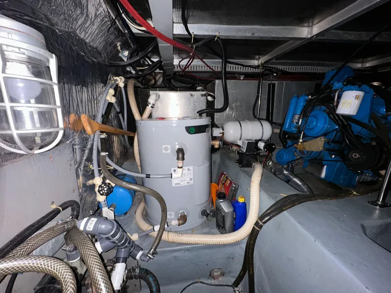 Slide: The Image of 1993 Carver Cruiser 440 engine room with machinery and hoses. - 46