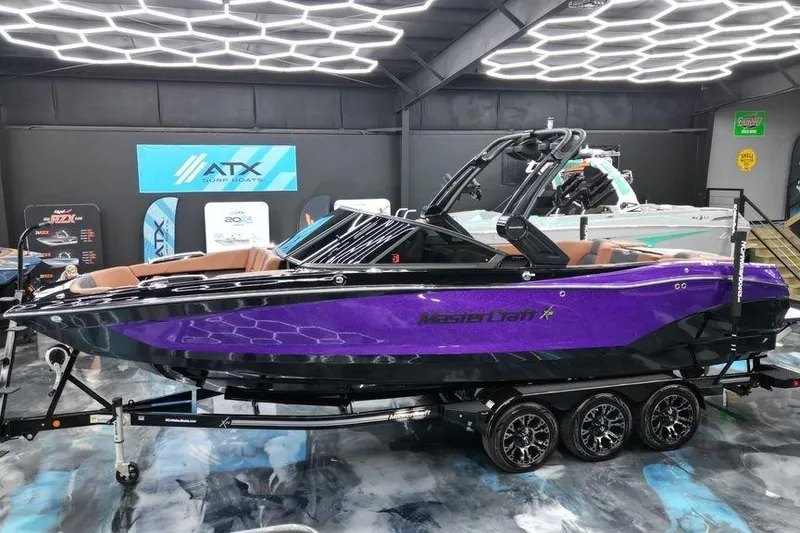 The Image of 2022 MasterCraft X26 boat in showroom, vibrant purple exterior, sleek design. - 0