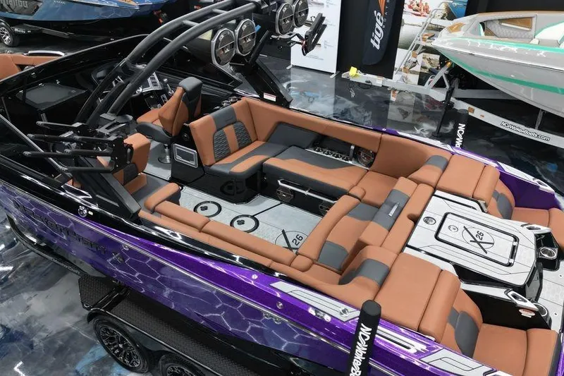 Slide: The Image of 2022 MasterCraft X26 boat with luxurious brown seating and sleek purple exterior. - 2