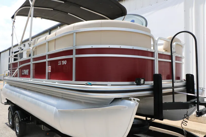 Slide: The Image of 2016 Lowe SS 190 pontoon boat with red and beige design on a trailer. - 11