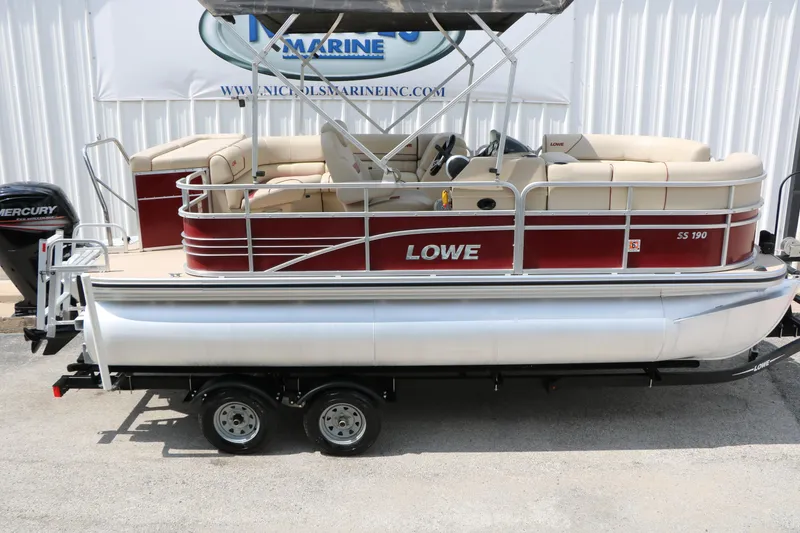 Slide: The Image of 2016 Lowe SS 190 pontoon boat with red and beige seating, on a trailer. - 12