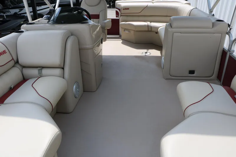 Slide: The Image of Interior of a 2016 Lowe SS 190 pontoon boat with beige seating and red accents. - 16
