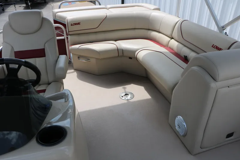 Slide: The Image of 2016 Lowe SS 190 boat interior with beige and red seating, steering wheel, and cup holder. - 29