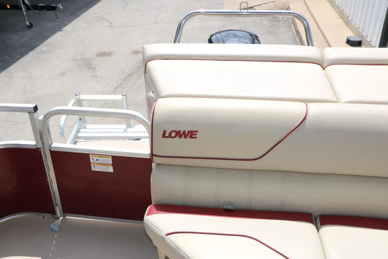 Slide: The Image of 2016 Lowe SS 190 boat interior with beige and red seating, docked outdoors. - 32