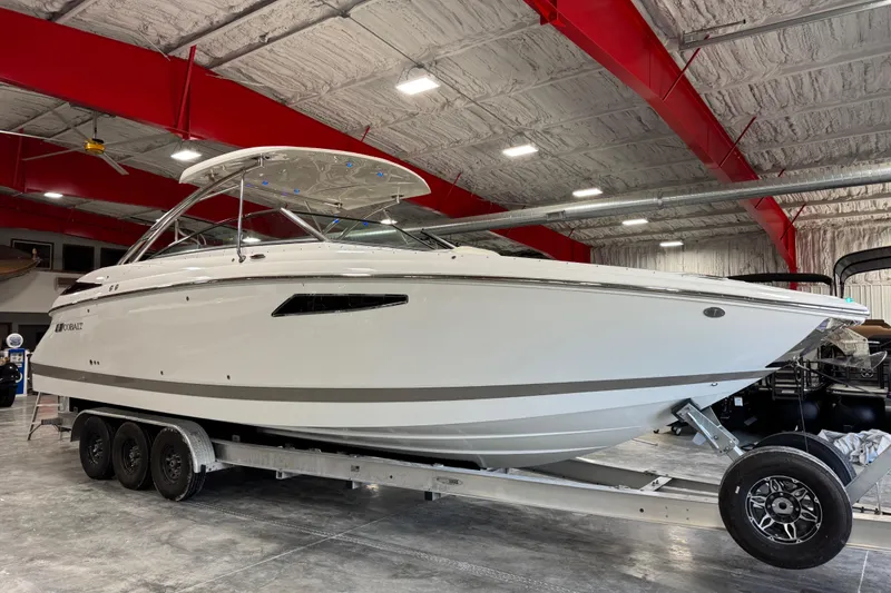 The Image of 2018 Cobalt boat on trailer in a spacious indoor facility with red beams. - 1