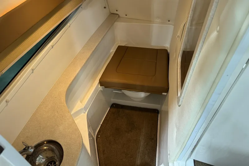 Slide: The Image of Compact boat cabin interior with cushioned seat, sink, and carpeted floor, Cobalt 2018 model. - 17