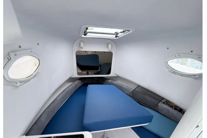 Slide: The Image of Interior cabin of 2001 Pro-Line 260 Walkaround boat with blue seating and portholes. - 10