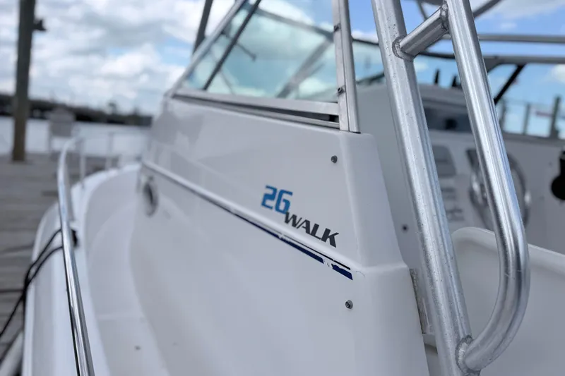 Slide: The Image of 2001 Pro-Line 260 Walkaround boat docked, showcasing sleek design and railing details. - 5
