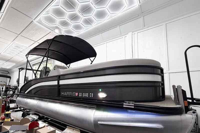 The Image of 2022 Harris Sunliner 230 pontoon boat in a showroom with modern lighting. - 0