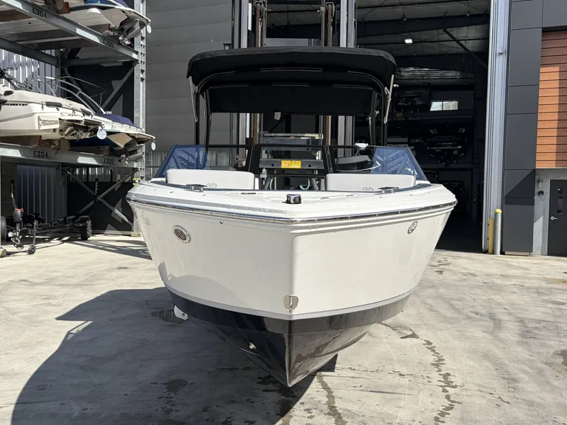 Slide: The Image of 2025 Cobalt CS23 Surf boat in storage facility. - 2