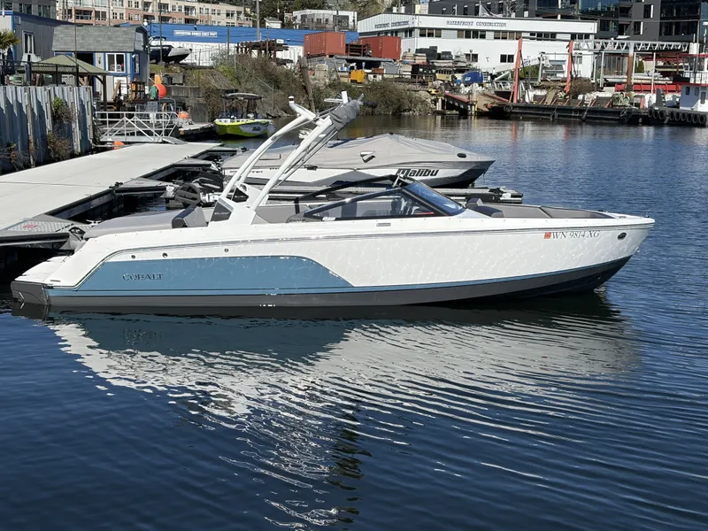 Slide: The Image of 2025 Cobalt CS23 Surf boat docked at harbor. - 3
