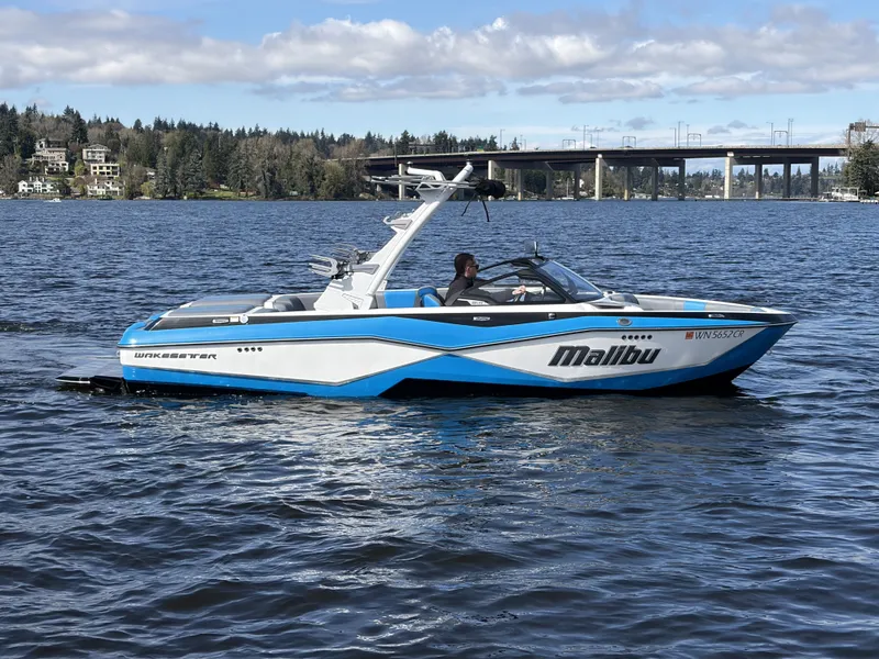 Slide: The Image of 2025 Malibu Wakesetter 22 LSV on a serene lake. - 5