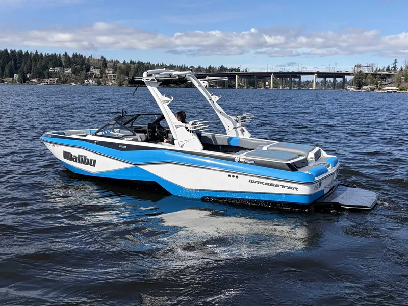 Slide: The Image of 2025 Malibu Wakesetter 22 LSV on a serene lake. - 8