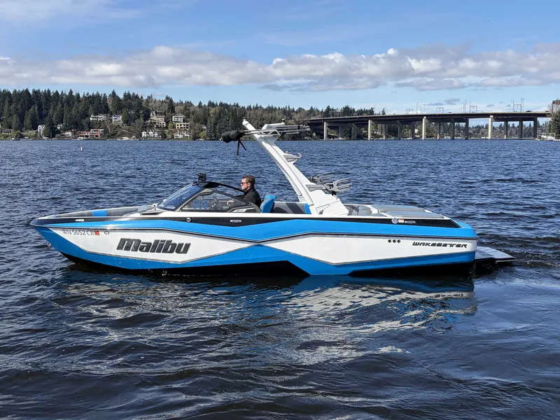 Slide: The Image of 2025 Malibu Wakesetter 22 LSV on a serene lake. - 9