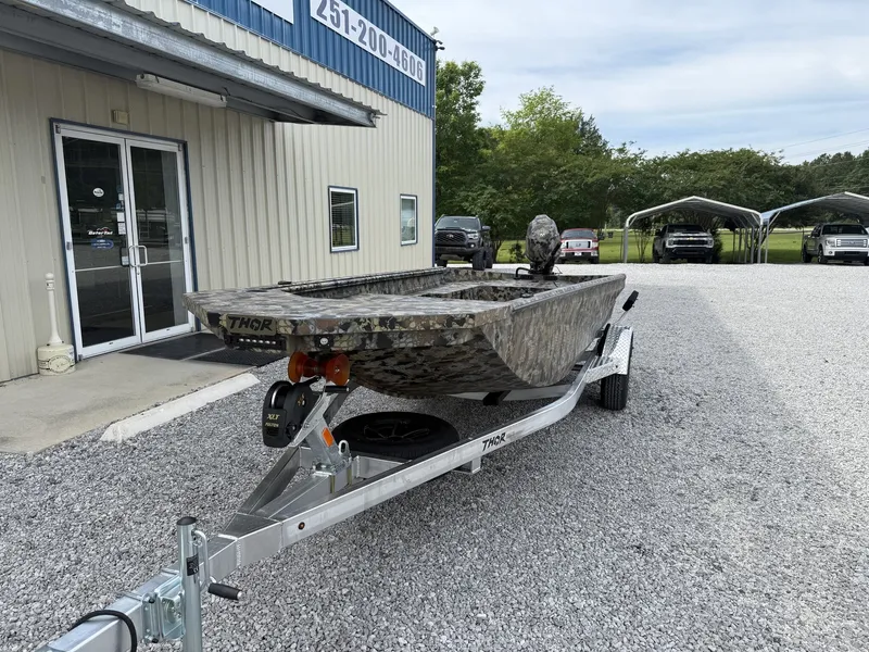 Slide: The Image of 2026 Thor Fish Hammer boat on trailer outside building. - 2