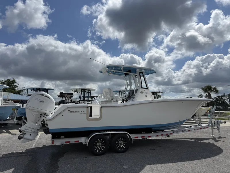 Slide: The Image of 2026 Tidewater 272 CC Adventure boat on trailer under cloudy sky. - 2