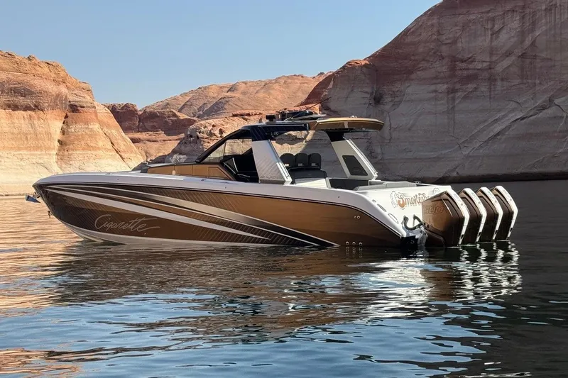 The Image of 2024 Cigarette 42' Auroris boat on calm water with scenic rocky backdrop. - 0