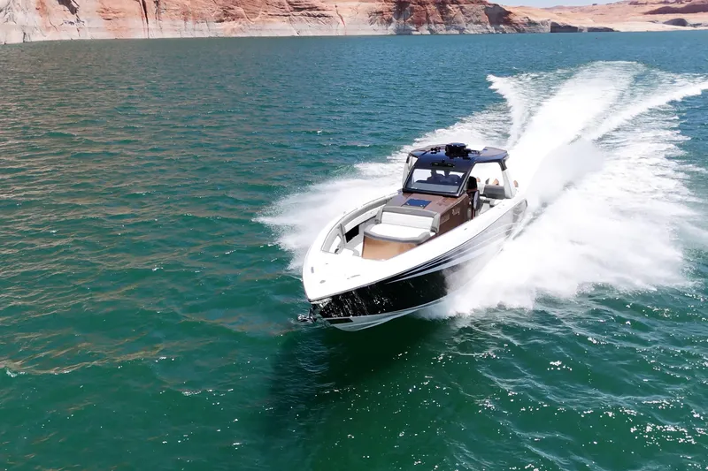The Image of 2024 Cigarette 42' Auroris speedboat cruising on open water with scenic cliffs in background. - 1